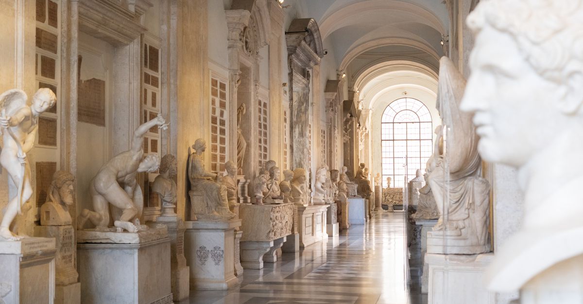 Elegant museum hallway with classical sculptures, showcasing Renaissance architecture and art.